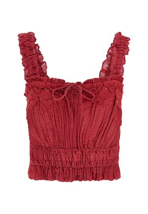 Top rouge court avec des bretelles volantes, un bord en dentelle complexe et un corsage froncé avec un détail à nouer à l'avant. Tissu texturé.