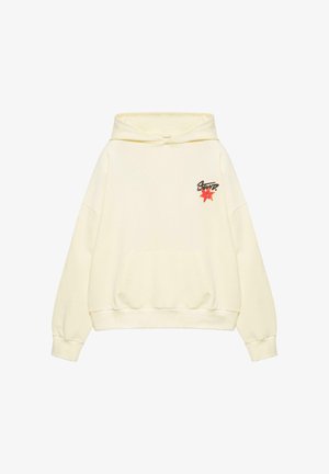 Felpa con cappuccio color crema con tasca frontale, piccolo fiore rosso e testo nero stilizzato sul petto in alto a sinistra.