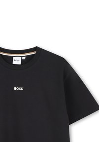 Melnas kokvilnas T-kreklas ar īsām piedurknēm, apaļu izgriezumu un atstarotāju "BOSS" logotipu uz krūškurvja. Iekļauta smalka svītru detaļa apkaklē.