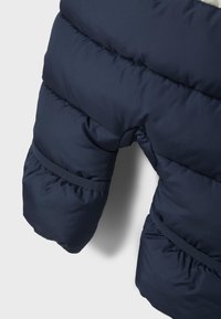 Jūras kara flotes sildīts ziemas sniega kostīms ar quilted tekstūru, ar elastīgām aprocēm un apaļu formu, izstrādāts siltumam un aizsardzībai.
