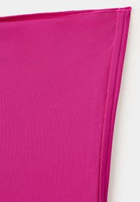 Tissu rose vif avec un coin replié, montrant une fine texture textile et des bords cousus sur un fond blanc.