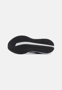 Semelle de chaussure avec une texture en caoutchouc noir, présentant une bande blanche au milieu et un motif de semelle pour l'adhérence et la durabilité.