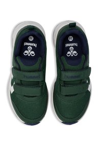 Grüne Sportschuhe mit Velcro-Riemen und weißen Details, von oben betrachtet, mit einem marineblauen Innenfutter und einem Logo auf der Zunge.