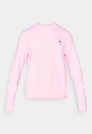 Różowy sweatshirt z długimi rękawami i okrągłym dekoltem. Posiada małe czarne logo na lewej piersi oraz gładką, miękką fakturę materiału.