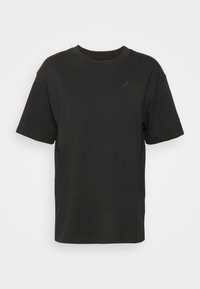 T-shirt nera in cotone con maniche corte, scollo tondo e un piccolo logo ricamato sul petto. Orlo dritto e vestibilità rilassata.