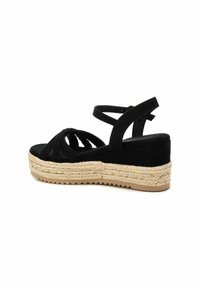 Sandalo espadrilles con platform in suede nero, design intrecciato, cinturino alla caviglia e zeppa rivestita in juta. Suola testurizzata per una migliore aderenza.