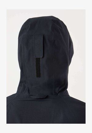 Črna nepremočljiva jakna s kapuco z gladko teksturo, ki ima detajl z Velcro trakom na zadnji strani in minimalističen dizajn.