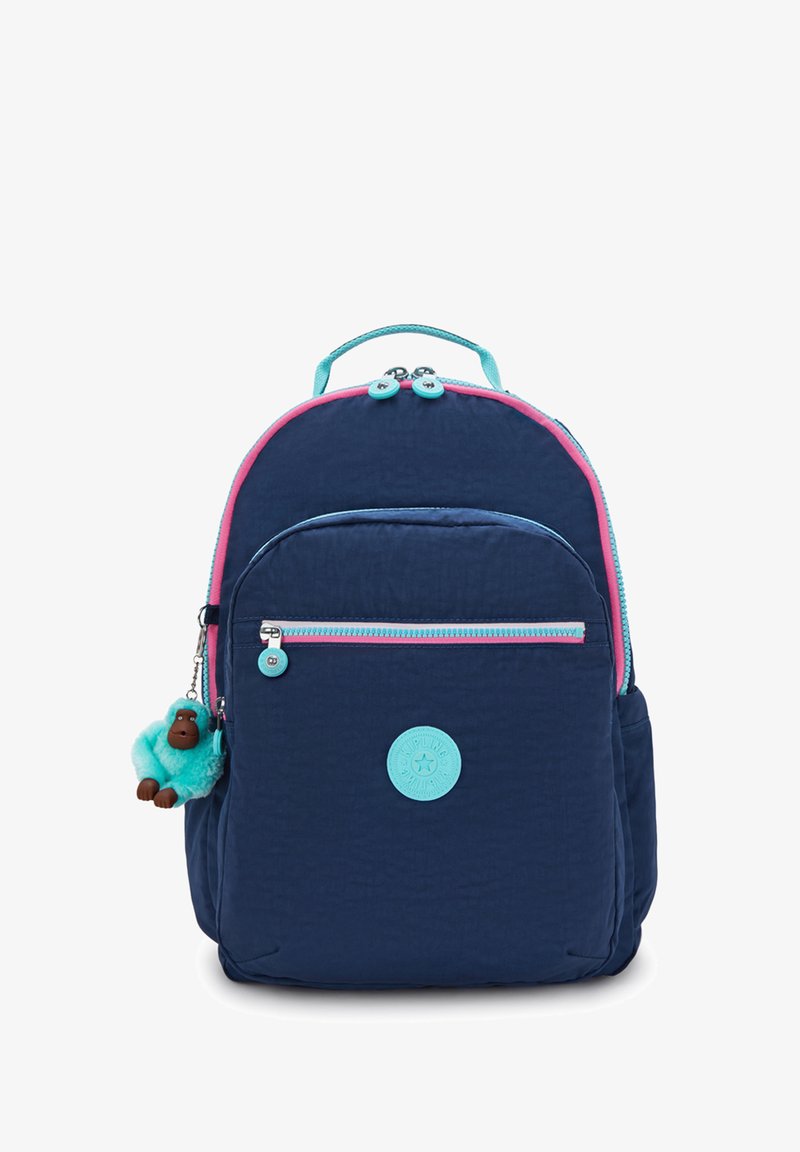 Marinblå ryggsäck med rosa och turkosa dragkedjor, framficka, handtag på toppen och en liten turkos plyschapa nyckelring fäst på sidan.