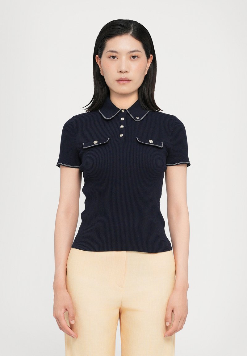 Navy ribbed polo shirt with short sleeves, white trim, a buttoned placket, and two front pockets with button accents.