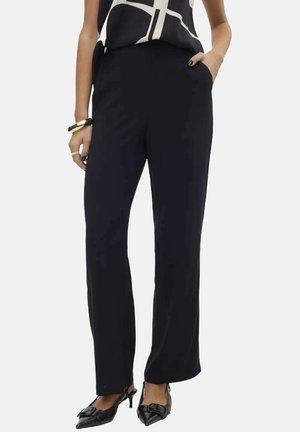 Pantalons noirs à jambe droite en tissu lisse, dotés de poches latérales et d'une taille structurée, associés à un haut à motif.