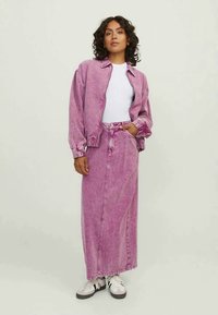 Jaqueta de ganga rosa com punhos e gola canelados, combinada com uma saia longa a condizer, apresentando um fecho de botão à frente e bolsos laterais.
