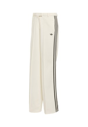 Pantalones de pierna ancha color crema con bandas laterales dobles negras, pliegues en la parte delantera y un pequeño logotipo negro en el muslo izquierdo.