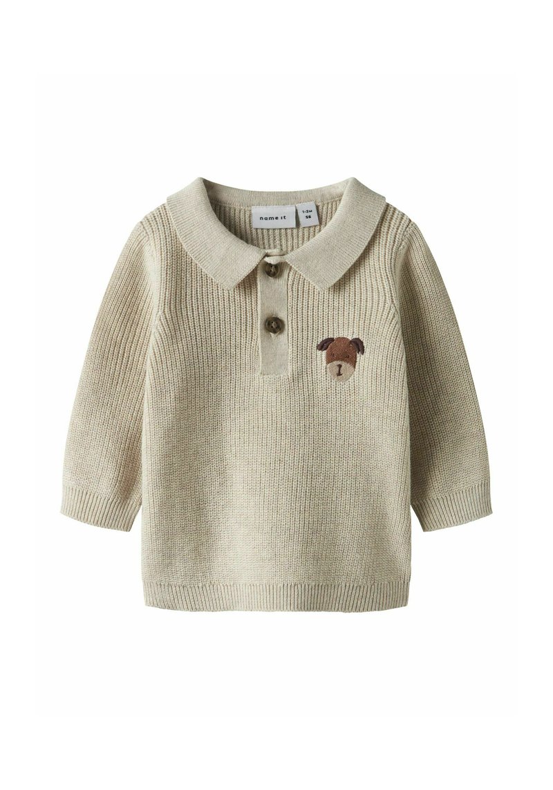 Polo beige a maglia con maniche lunghe, caratterizzata da una patta con due bottoni e un ricamo marrone a forma di cane sul petto. Materiale morbido e dalla texture. 