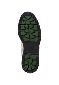 La semelle de chaussure présente un intercalaire en caoutchouc vert et un relief en noir. Conçue pour offrir une bonne adhérence avec un motif strié et une flexibilité dans l'amorti.