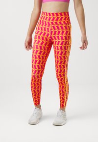 Leggings di un vivace colore rosa fucsia con un motivo di banane gialle. Design a vita alta con doppie strisce bianche sui lati e materiale elastico.