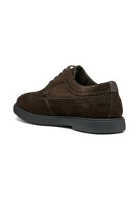 Scarpe in suede marrone con dettagli perforati, punta tonda e suola in gomma nera a contrasto. Progettate con lacci eleganti e un tacco discreto.