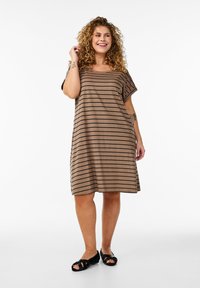 Robe brune à rayures, longueur genou, avec des manches courtes et une coupe ample. Tissu doux, design simple, portée avec des sandales noires.