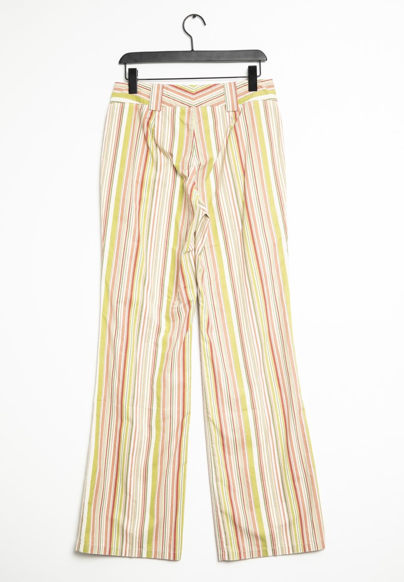 Pantalon rayé avec des lignes verticales vertes, orange et blanches suspendu à un cintre noir sur un fond blanc.