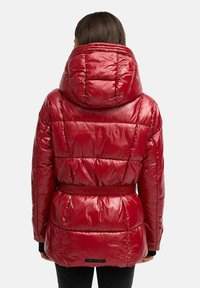 Rote Pufferjacke mit glänzender Oberfläche, großer Kapuze, tailliertem Bund und gestepptem Design. Mit elastischen Bündchen und geradem Saum.