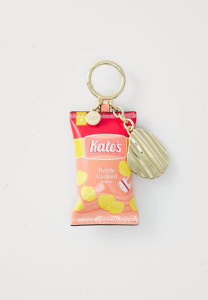 Chaveiro em forma de saco de snacks nas cores rosa e amarelo com "Kate's Kettle Cooked Original" impresso. Inclui um anexo de etiqueta texturizada em dourado.