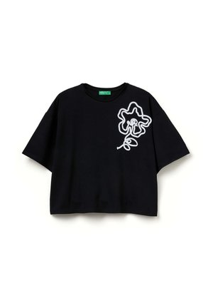 Černé bavlněné tričko volného střihu s bílým obrysem květinového motivu na levé straně a kulatým výstřihem.