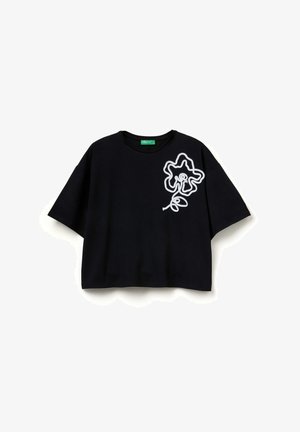 Schwarzes Baumwoll-T-Shirt mit lockerem Schnitt, ausgestattet mit einer weißen Umrisszeichnung einer Blume auf der linken Seite und einem rundem Ausschnitt.