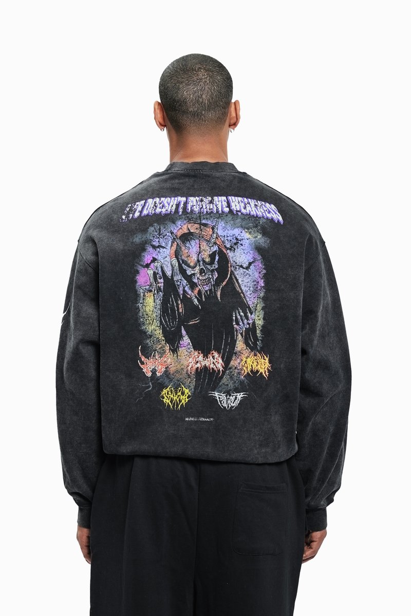 Black oversized sweatshirt featuring a colorful graphic on the back, depicting a skull with hands, and various text elements in vibrant colors.