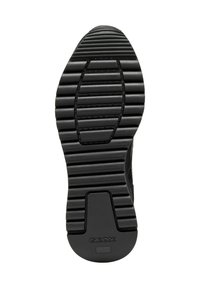 Semelle de chaussure en caoutchouc noir avec des rainures horizontales et de petits crans circulaires ; présente un logo Geox près du talon. Fini durable et texturé.
