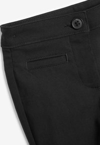 Schwarze Hosen aus glattem Stoff mit einem normalen Bund, einem Knopfverschluss und einer Gesäßtasche mit horizontalem Eingang.