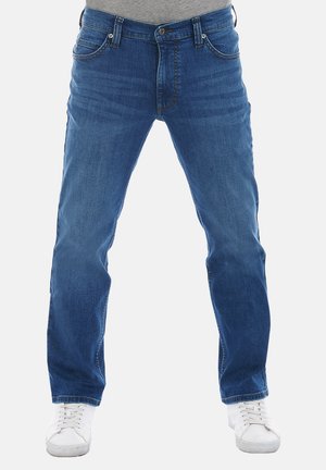Blue denim jeans with a classic straight fit, featuring five pockets and a zip fly. Worn with white sneakers.