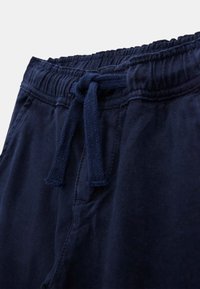 Mjukt mörkblåa shorts med elastisk midja och snörning. Tyget har en mjuk textur och har sidofickor.
