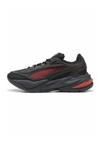 Scarpe sportive nere con una parte superiore testurizzata, dettagli rossi sui lati e una suola in gomma spessa con un design unico.