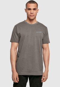 Gray cotton t-shirt with short sleeves, featuring a crew neck and blue "DYSTOPIA" logo printed on the left side of the chest.