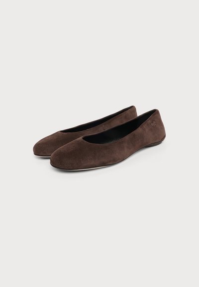 Paire de ballerines en daim marron foncé avec bouts arrondis et talons plats sur un fond clair uni.
