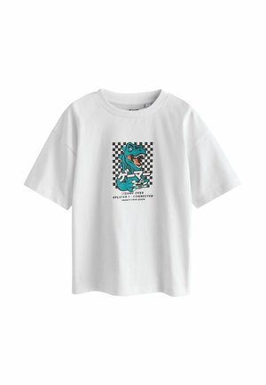 Fehér rövid ujjú póló, amelyen türkiz dinoszaurusz grafika látható, amint egy játékkonzol vezérlőt tart, fekete-fehér kockás háttérrel és játék témájú szöveggel.