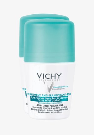 Two stacked roll-on deodorants in white containers with light blue caps. Labels feature text in French and English, indicating hypoallergenic formula.