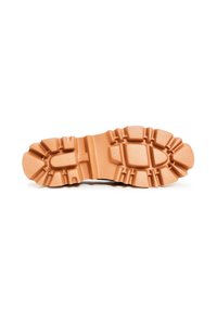 Semelle d'une botte en caoutchouc beige avec des motifs de crampons profonds et robustes pour la traction, présentée sur un fond blanc.