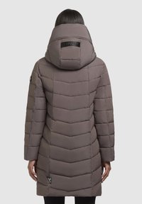 Manteau rembourré marron avec un design matelassé en chevrons, une grande capuche et des détails de logo au dos, doté de manches longues et d'une coupe mi-longue.