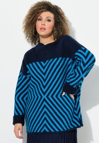 Pull rayé bleu et marine avec un motif géométrique, fabriqué en matière tricotée douce, doté d'une coupe décontractée et de poignets côtelés.