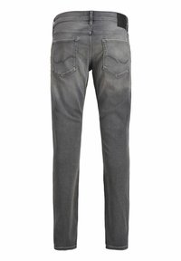 Jeans gris ajustados para hombre con bolsillos traseros y un sutil efecto de desgaste, mostrados desde la parte posterior sobre un fondo blanco.