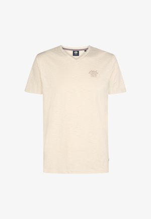 Camiseta de manga corta color crema con cuello en v, que presenta un estampado sutil en el área del pecho izquierdo y una tela texturizada.