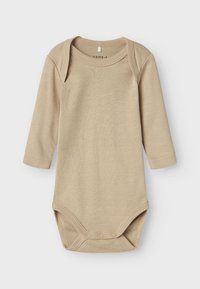 Beige Langarm-Bodysuit aus weicher Baumwolle. Verfügt über einen sanft abgerundeten Ausschnitt und Druckknöpfe am unteren Ende für ein einfaches Ankleiden.