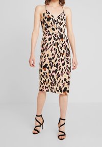 Leopard print midi dress in light beige with black, pink, and orange accents; features thin straps and a fitted silhouette.