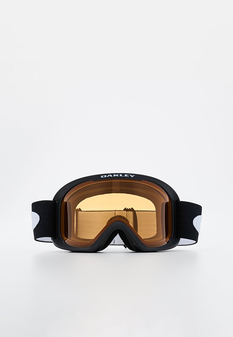 Czarne gogle narciarskie z bursztynową soczewką, piankowym wypełnieniem i regulowanym czarnym elastycznym paskiem z białymi akcentami. Wyświetlone logo marki.