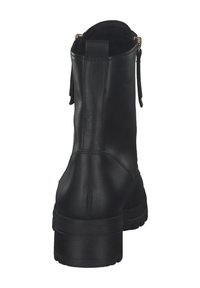 Cizme negre din piele cu glezna, cu vârful rotund, talpă robustă și două fermoare decorative pe spate. Textură netedă și cusături minime.