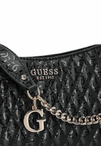 Borsa a tracolla nera trapuntata con logo "GUESS" e dettaglio in catena metallica. Presenta un materiale testurizzato e un charm decorativo in oro con la lettera "G".