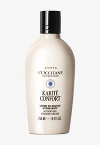 L'Occitane Karité Confort återfuktande duschkräm i en slät, oval, krämfärgad flaska med svart flip-top-kapsyl och etikett med detaljer. 250 ml.