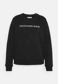 Felpa nera con collo rotondo, con "CALVIN KLEIN JEANS" in lettere maiuscole bianche sul petto, con maniche lunghe e polsini a costine.