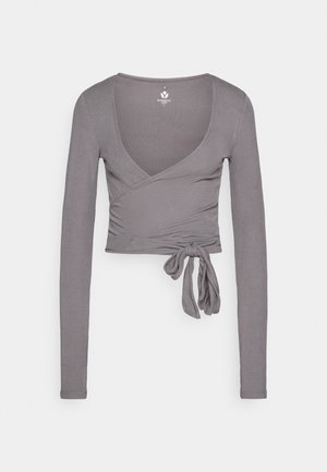 Top gris de manga larga con escote en V profundo, tejido texturizado y detalle de lazo en la cintura. Diseño limpio, sin patrones ni gráficos visibles.