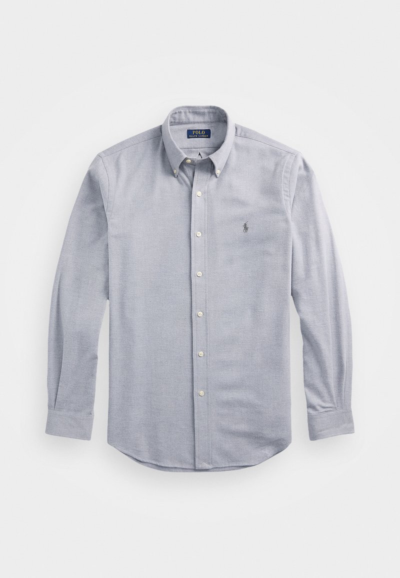 Vaaleansininen nappikauluspaita, joka on valmistettu kudotusta kankaasta. Ominaisuuksiin kuuluvat klassinen kaulus, pitkät hihat ja pieni brodeerattu logo rinnassa.